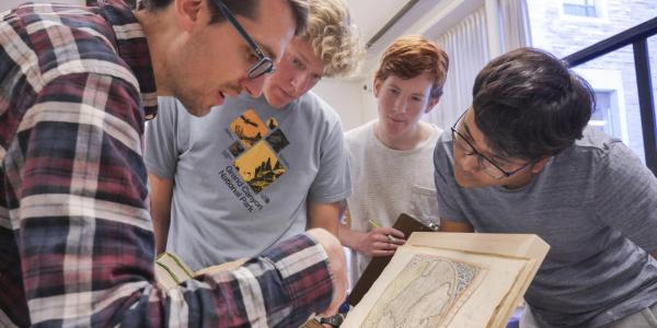 Students looking at an old history book