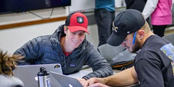 Two students looking at a laptop