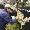 Student sticking a pin in a board that says "Where are you off to next?" at the 2023 Grad Bash celebration