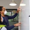A stock photo of two people working on a white board