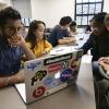 Students looking at a laptop in a classroom