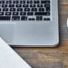 Stock photograph of a laptop, notebook and pen, and coffee