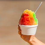 Person holding a cup of colorful shaved ice.