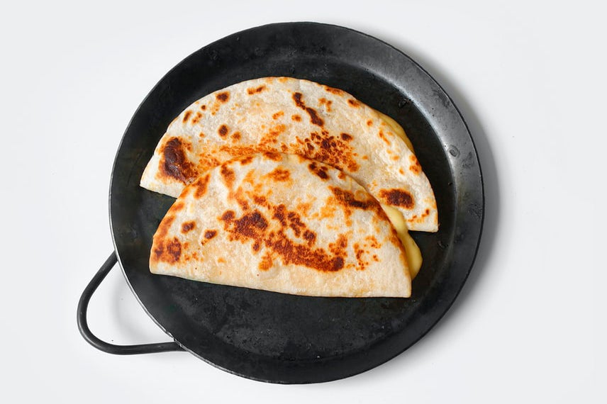 Plate with a toasted quesadilla cut in half.