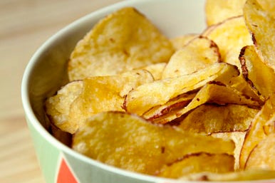 Colorful bowl full of homemade potato chips.