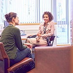 Photo of a faculty member meeting with a trauma counselor and advocate.