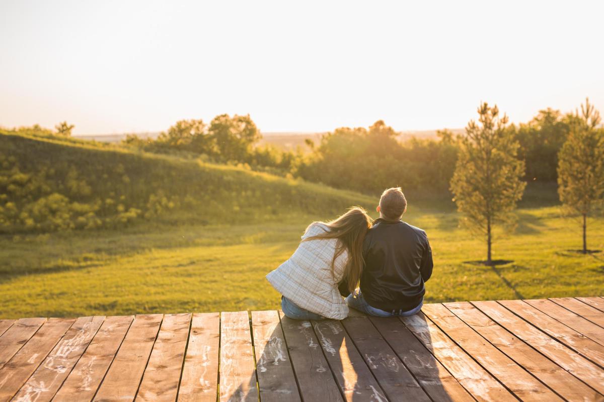 Photo of two people cuddled on a porch.