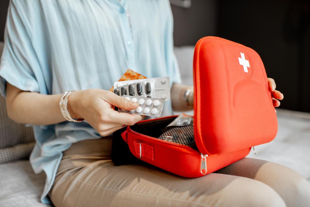 Photo of a person opening a first aid kit with nicotine cessation supplies inside.