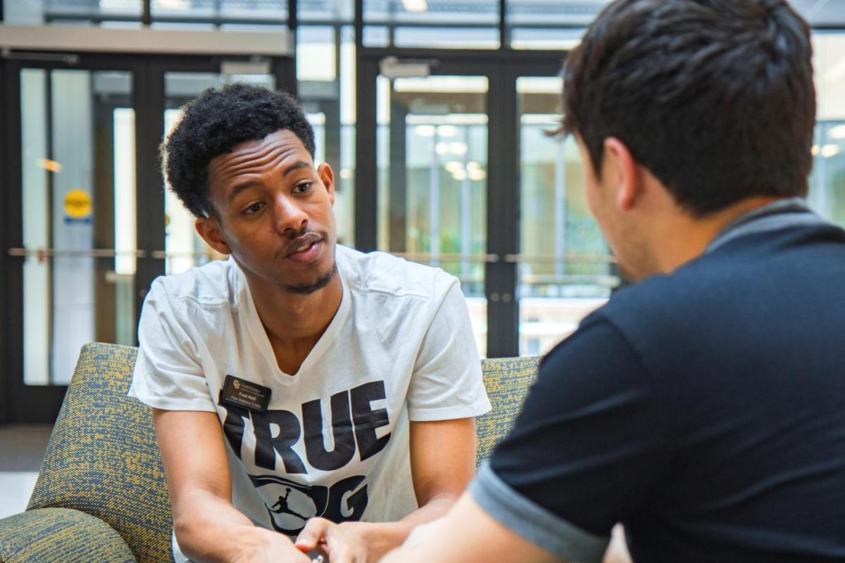 two students talking in a peer wellness coaching environment