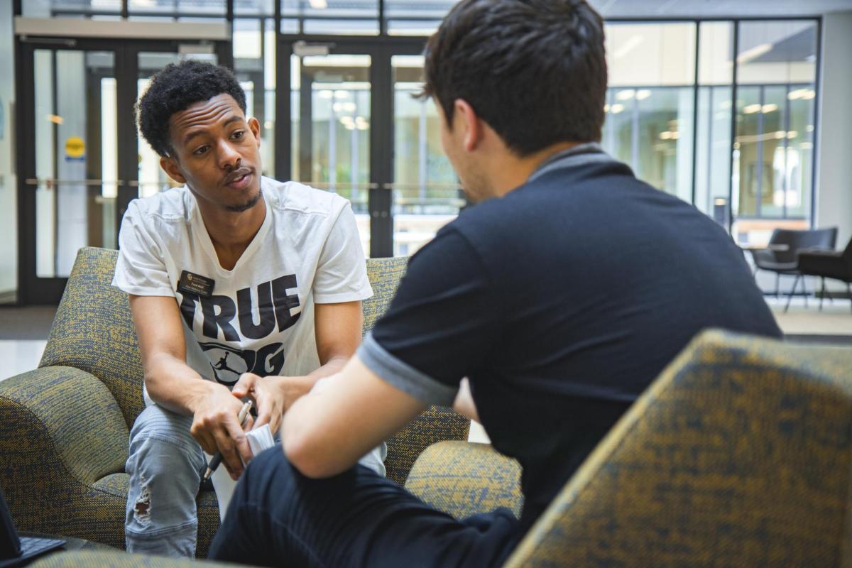 a peer wellness coach talking to a student
