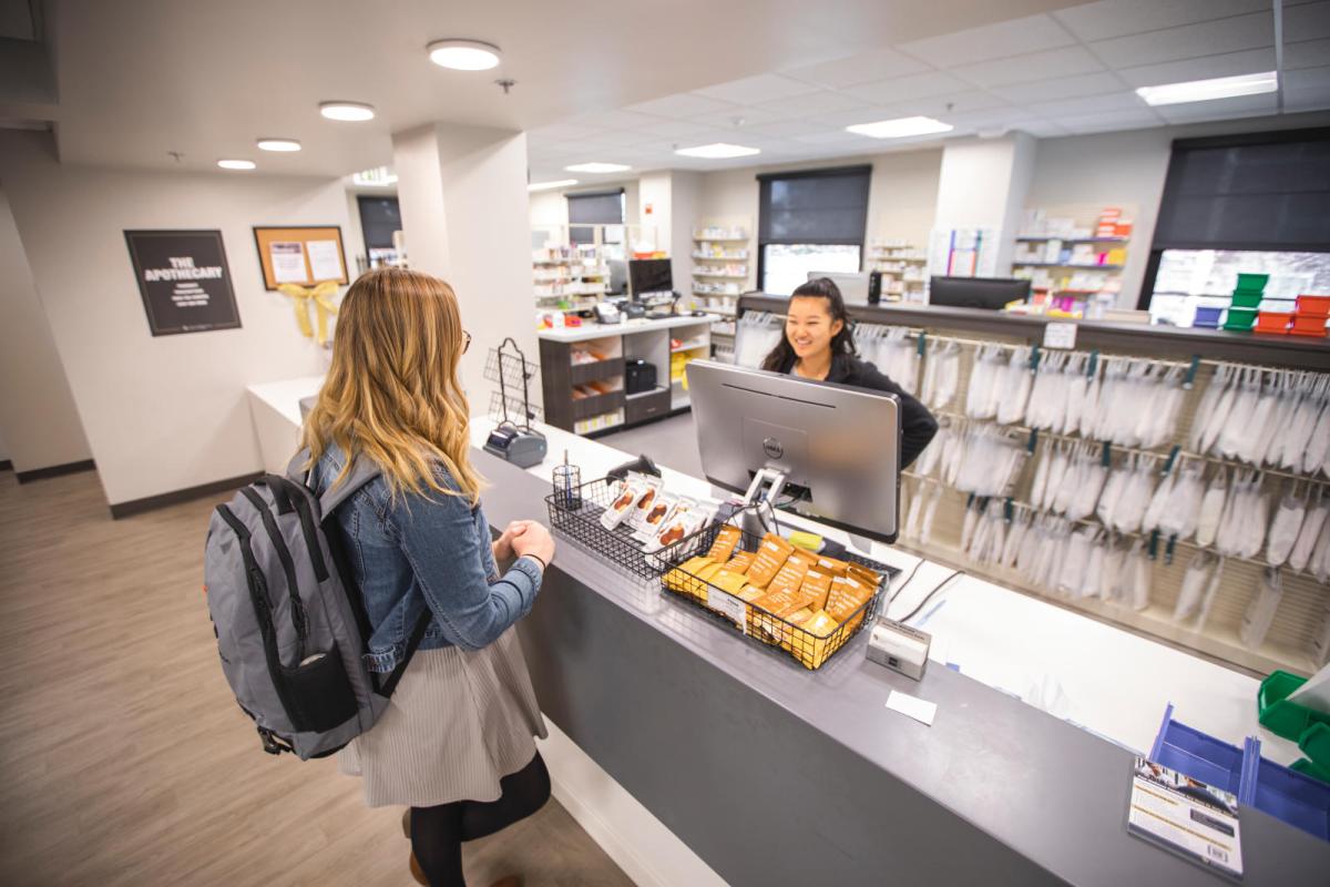 Photo of a student or staff member at the pharmacy in Wardenburg Health Center.
