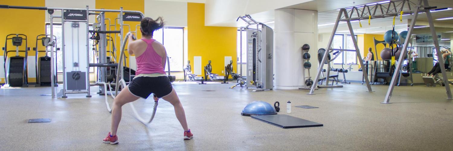 Female student using ropes in the functional fitness area