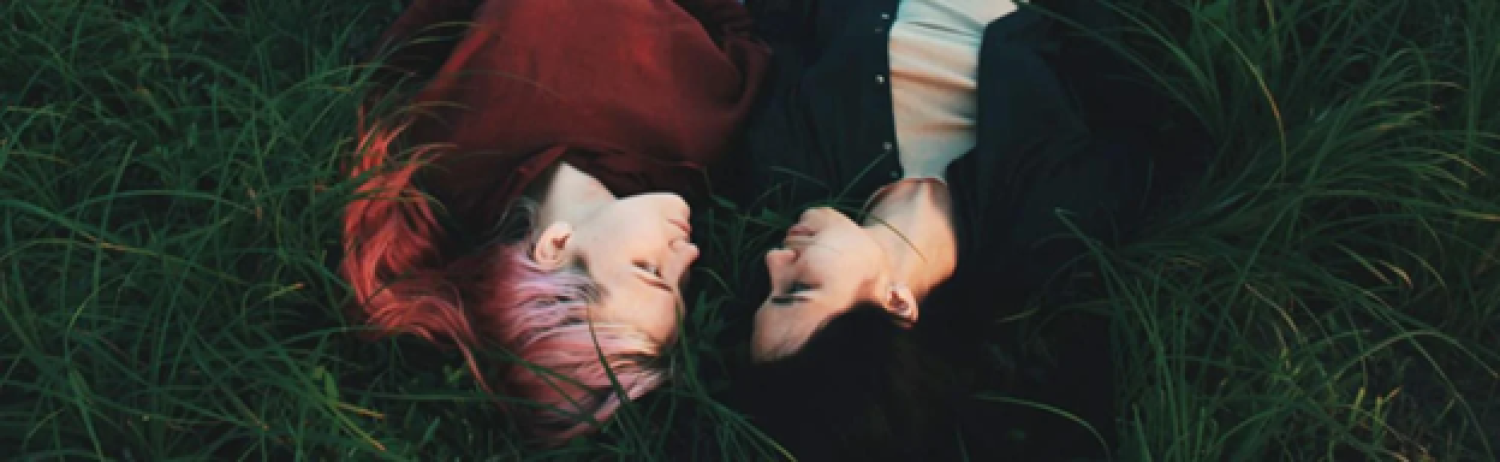 two people laying in grass