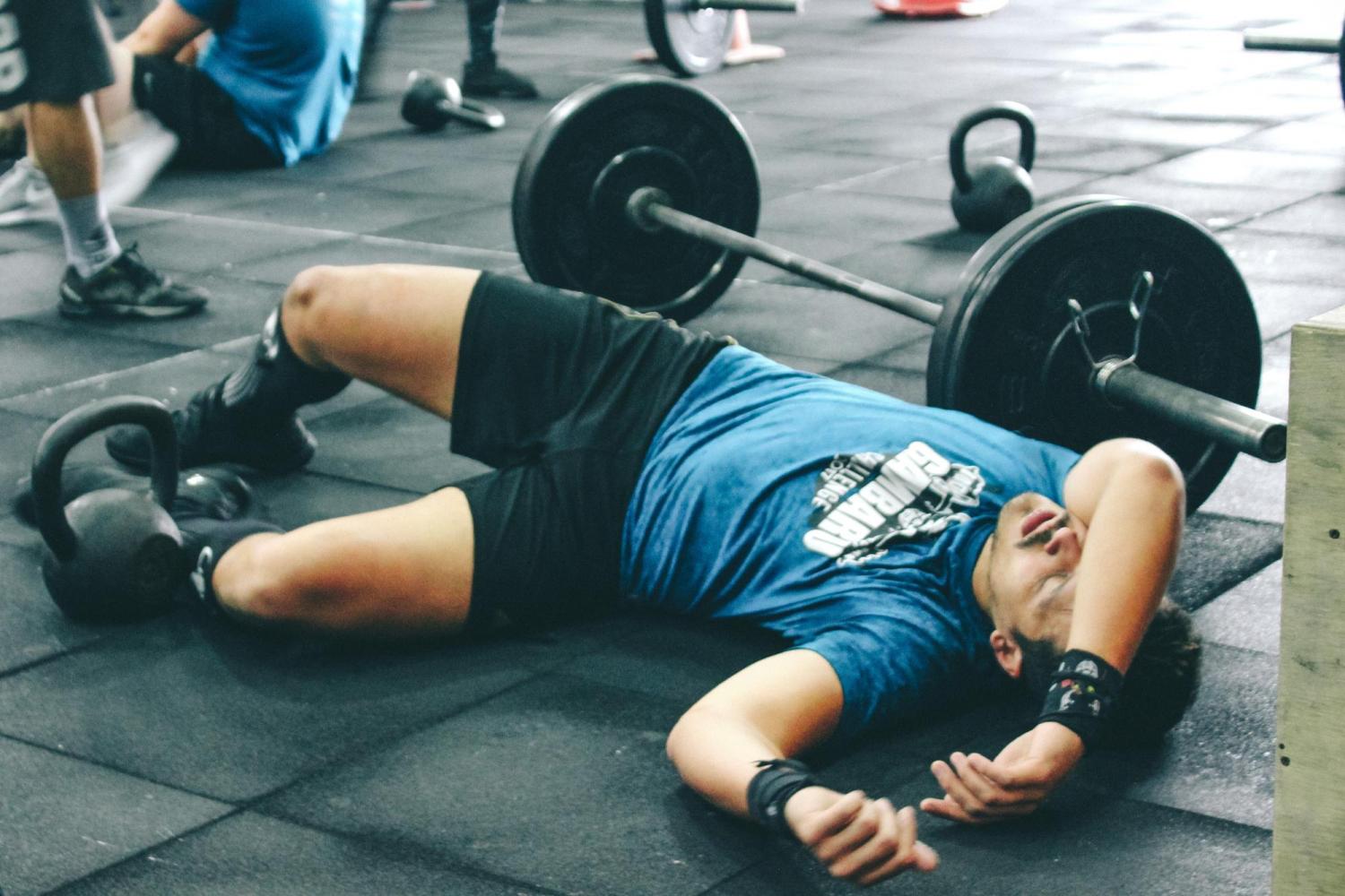 Man lying on the floor next to weights