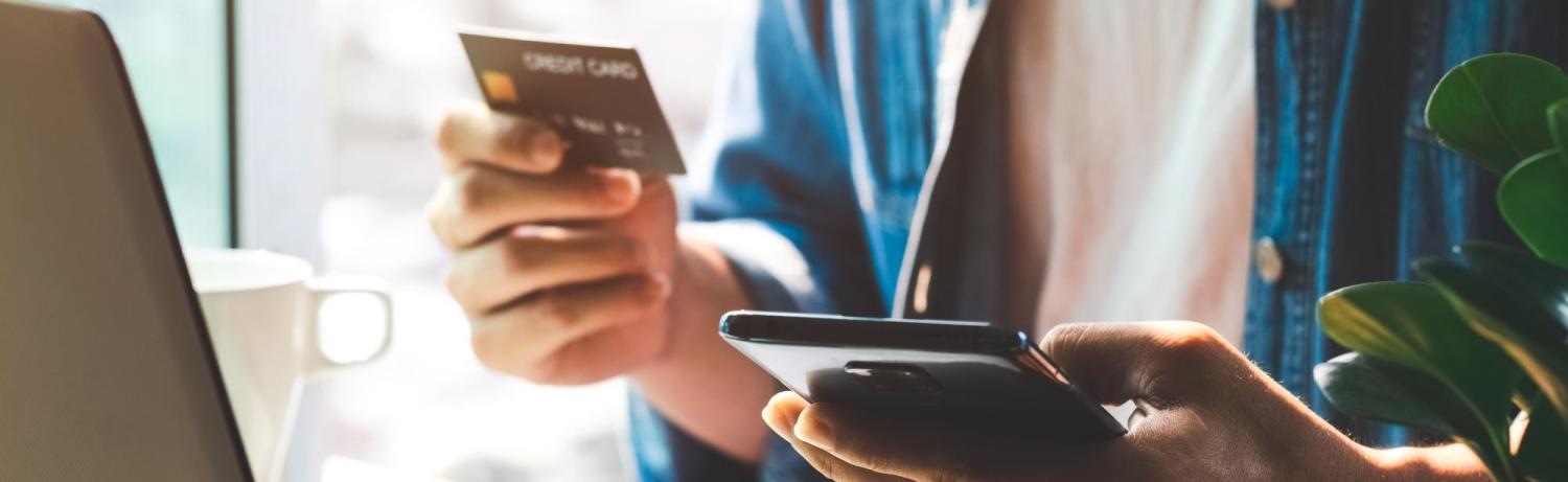 Person holding a phone and credit card