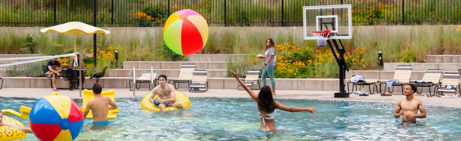 Photo of students hitting a large beach ball around the buff pool.