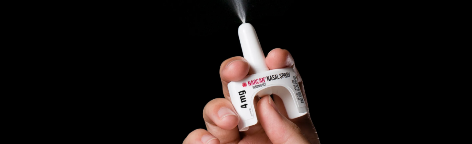 Photo of a person spraying naloxone.