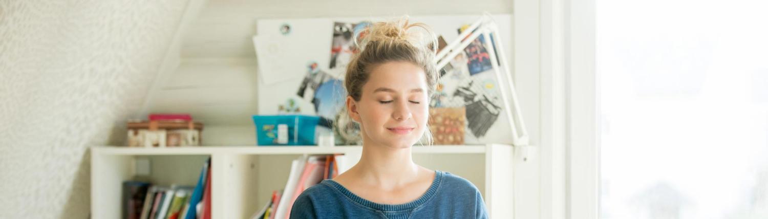 Girl meditating on her desk in her bedroom