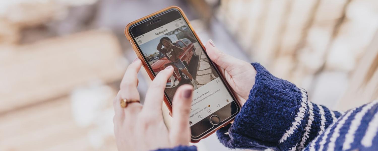 Girl looking at a photo of a friend on instagram