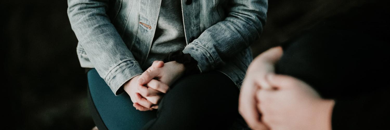 Two people sitting with their hands crossed