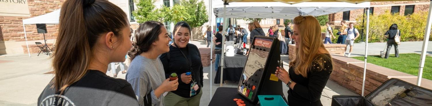 students talking to staff at the take care street fair