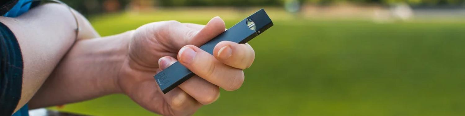 Photo of a person holding a vape.