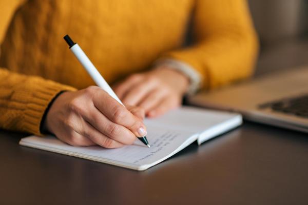 Close up of person writing in a notebook