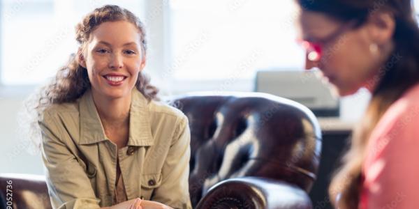 Photo of a staff member smiling at the camera during a counseling appointment.