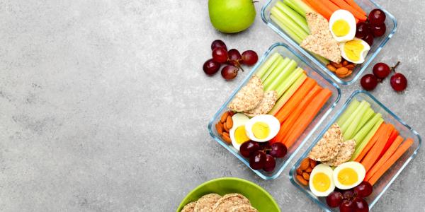 Photo of tupperware filled with hardboiled eggs, crackers and veggie sticks.