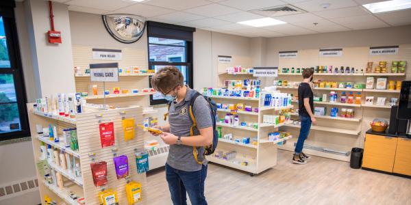 Photo of students browsing the shelves at the pharmacy.