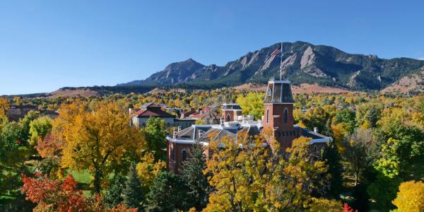 Photo of old main and the flatirons in fall colors. 