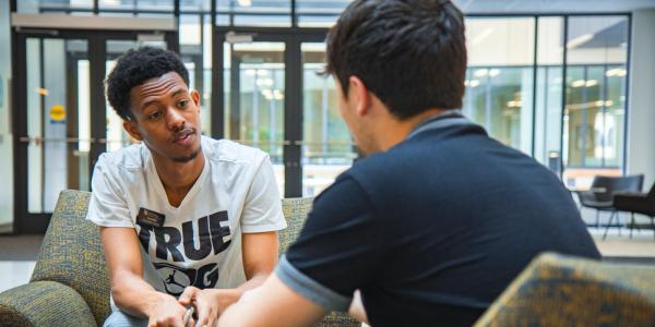 Student speaking with a Peer Wellness Coach at the CASE building.