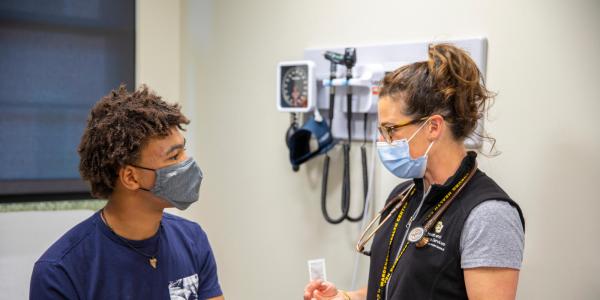 Student and provider talking to each other in an exam room at Wardenburg Health Center during a routine visit. 