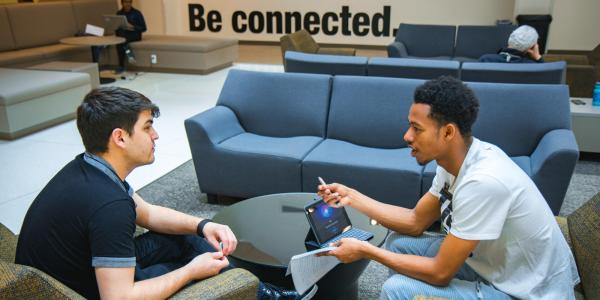 Photo of a student meeting with a Peer Wellness Coach in the Case building.