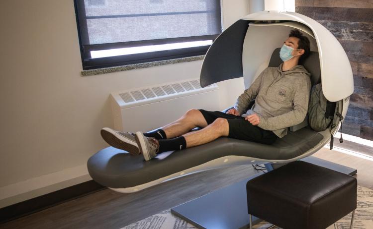 student in a sleeping pod napping