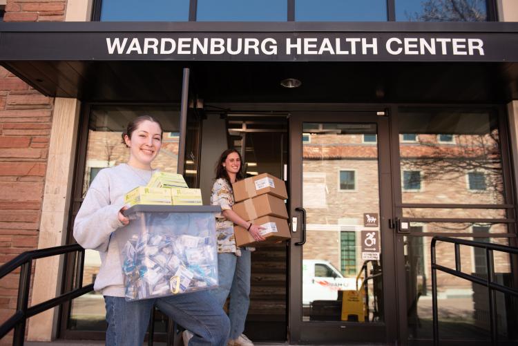 students carry boxes outside Wardenburg