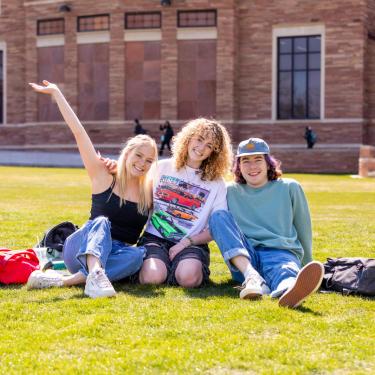 students sitting in grass