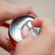 Photo of a person opening a sealed can at a party.