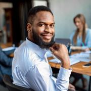 Photo of a man smiling during a team meeting.