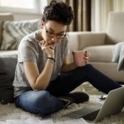 Girl sitting on the floor with her laptop and a mug