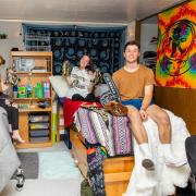 Students sitting on beds in dorm room with cu boulder gear