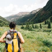 Person standing on a trail in a backpack. 