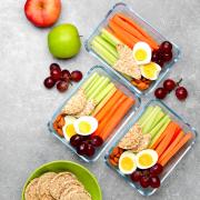 Photo of tupperware filled with celery, hard boiled eggs, carrots and crackers.