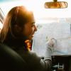 Photo of two friends looking at a road map while parked in a car at sunset.