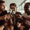 Photo of three male students playing a drinking game.