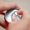 Photo of a person opening a sealed can at a party.
