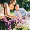 Photo of a couple enjoying a picnic with flowers.