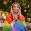 Photo of a student draped in a pride flag.
