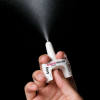 Photo of a person spraying naloxone.