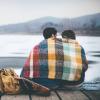 couple sitting under blanket outside in winter